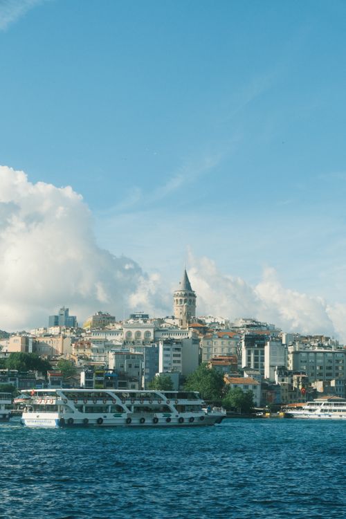 Free Captivating view of Galata Tower, skyline, and boats on the Bosphorus, under a clear blue sky. Stock Photo