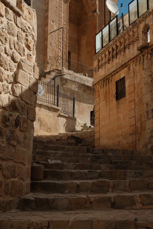 Free Rustic stone stairway leading through historic architecture in a sunlit old town setting. Stock Photo