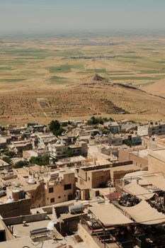 Explore a Middle Eastern town with surrounding desert landscape from above.