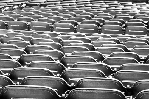 Free A geometric pattern of empty stadium seats in black and white, capturing a classic architectural symmetry. Stock Photo