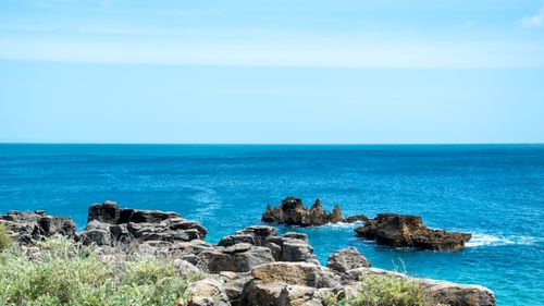 Free Explore the stunning rocky cliffs and vivid turquoise waters along the coast of Cascais, Lisboa. Stock Photo