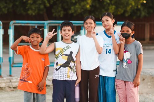 Free A cheerful group of children striking poses outside with playful gestures and smiles. Stock Photo