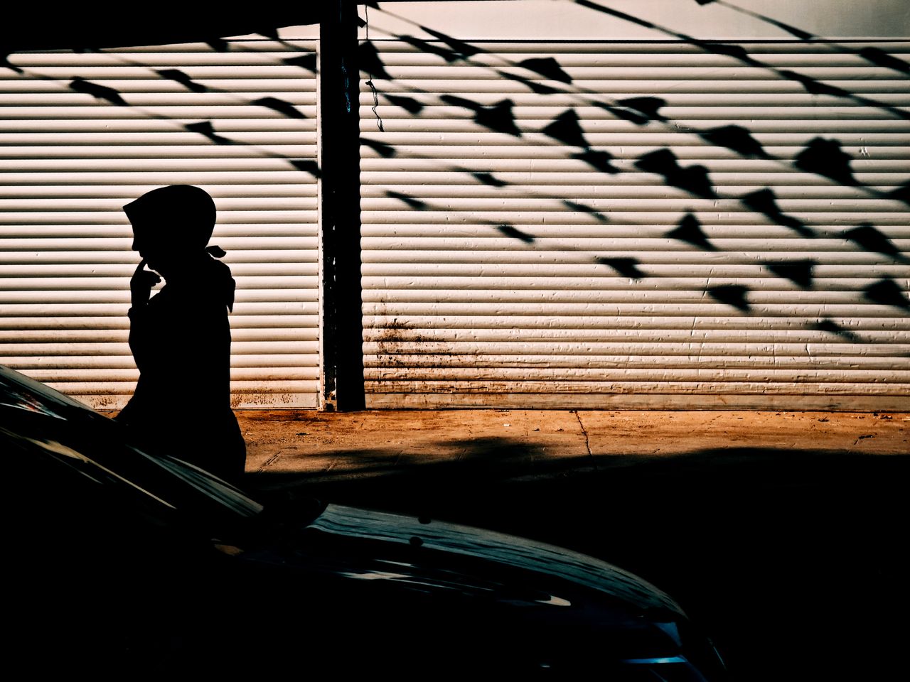 a silhouette of a person walking along a sunlit street in istanbul cas