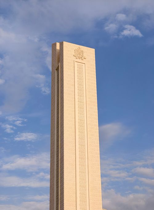 Free A striking beige tower reaching into the clear blue sky, displaying intricate designs. Stock Photo