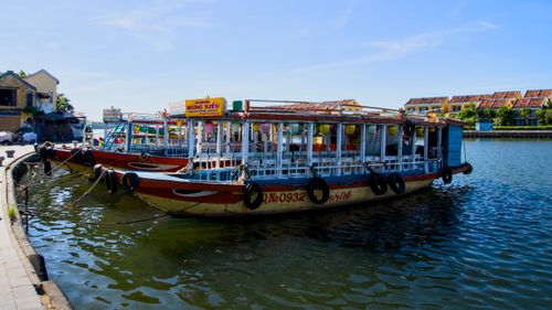 Free Vibrant tourist boats docked on a sunny river in a picturesque town. Stock Photo