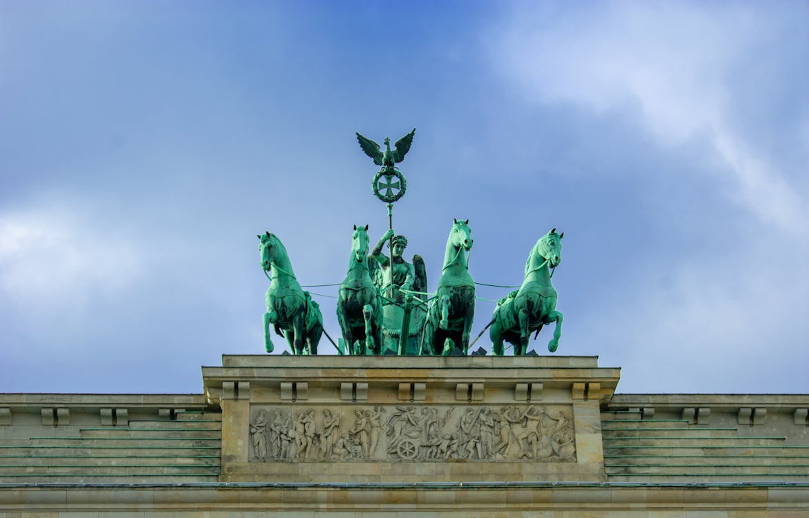 Brandenburg Gate with sculptures of quadriga under blue cloudy sky