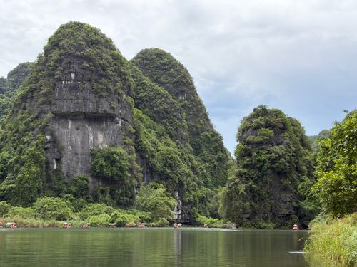 Free Lush karst mountains reflecting in the tranquil river in Ninh Binh, Vietnam. Stock Photo