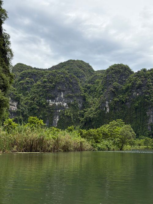 Free Serene view of lush limestone mountains over a tranquil river in Vietnam, perfect for nature enthusiasts. Stock Photo