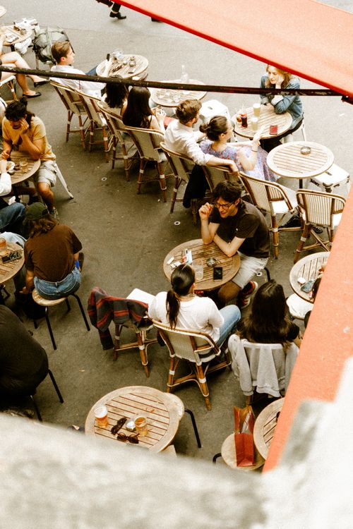Free People enjoy leisure at a lively street café, capturing the essence of European city life. Stock Photo