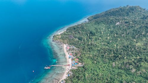 Free Stunning aerial photo of lush island and clear blue ocean waters. Stock Photo
