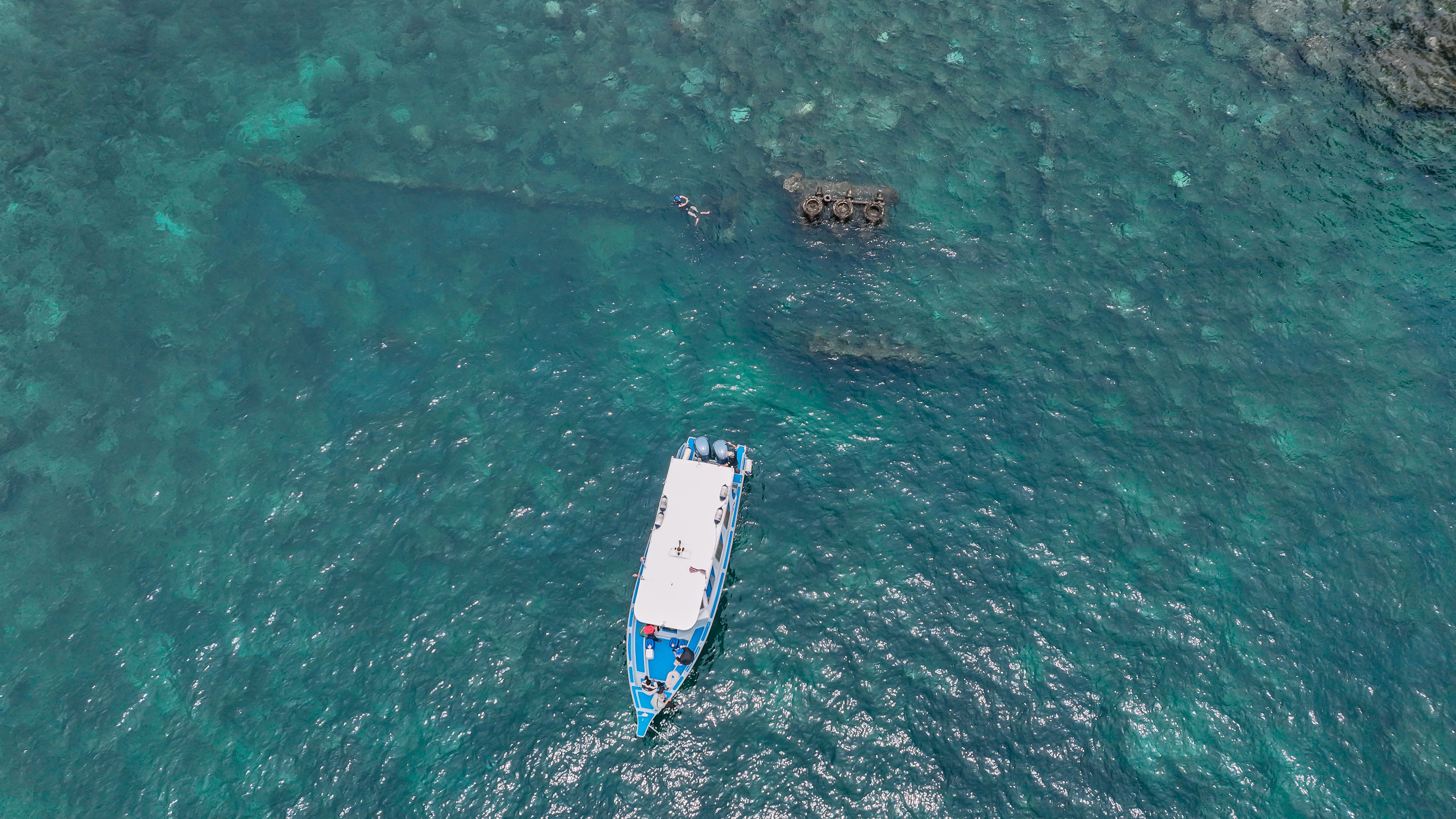 solo diver sharing a boat with new friends in crystal-clear Fijian water