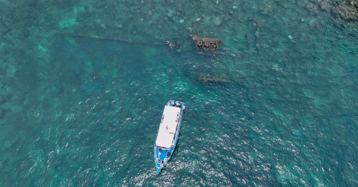 solo diver sharing a boat with new friends in crystal-clear Fijian water