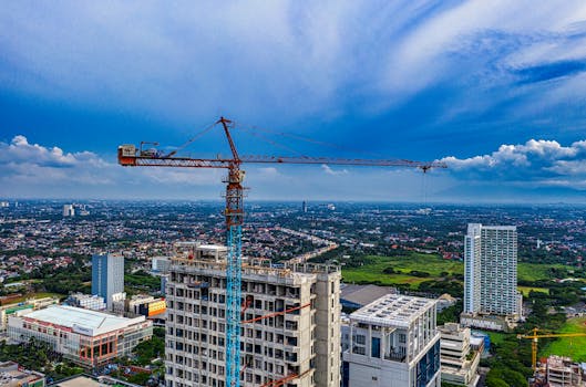 蔚蓝的天空下，一架塔式起重机矗立在印度尼西亚万丹市的一处建筑工地上空