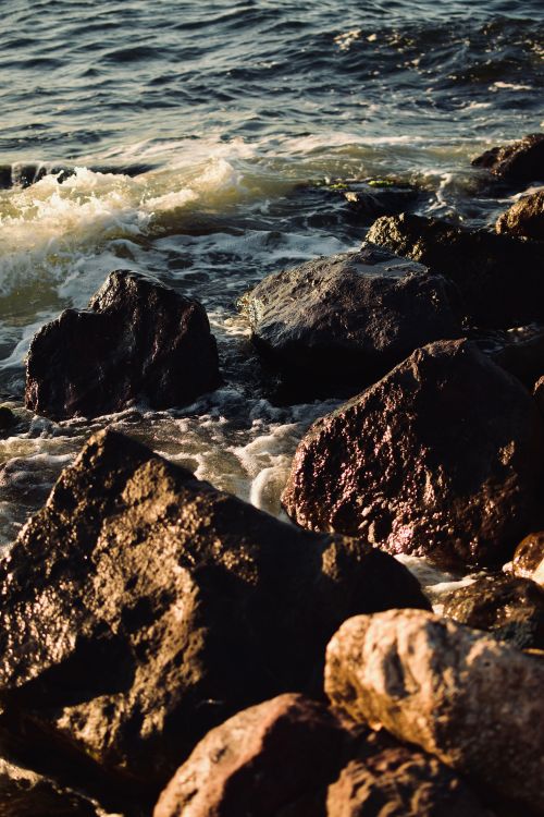 Free Golden sunlight over rocky shoreline with waves in Bursa, Türkiye. Stock Photo