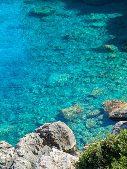 Free Stunning clear blue water at a rocky coastline in a serene summer scene. Stock Photo