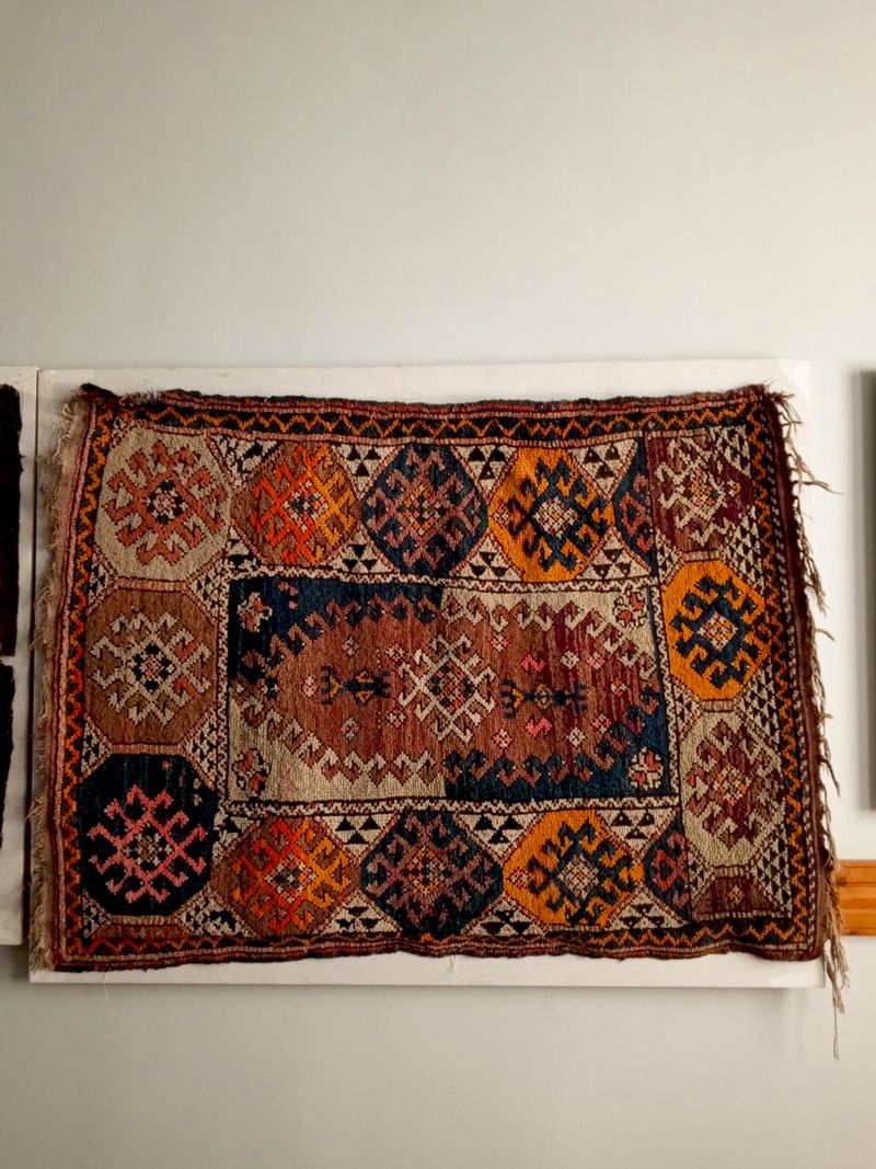 Vintage handwoven rug with geometric patterns on a wall — photo by sena on Pexels