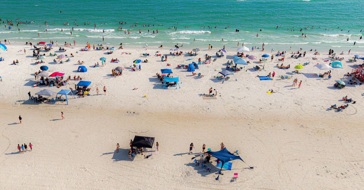 A vibrant aerial view of a busy beach day at Cayo Siesta, Florida.
