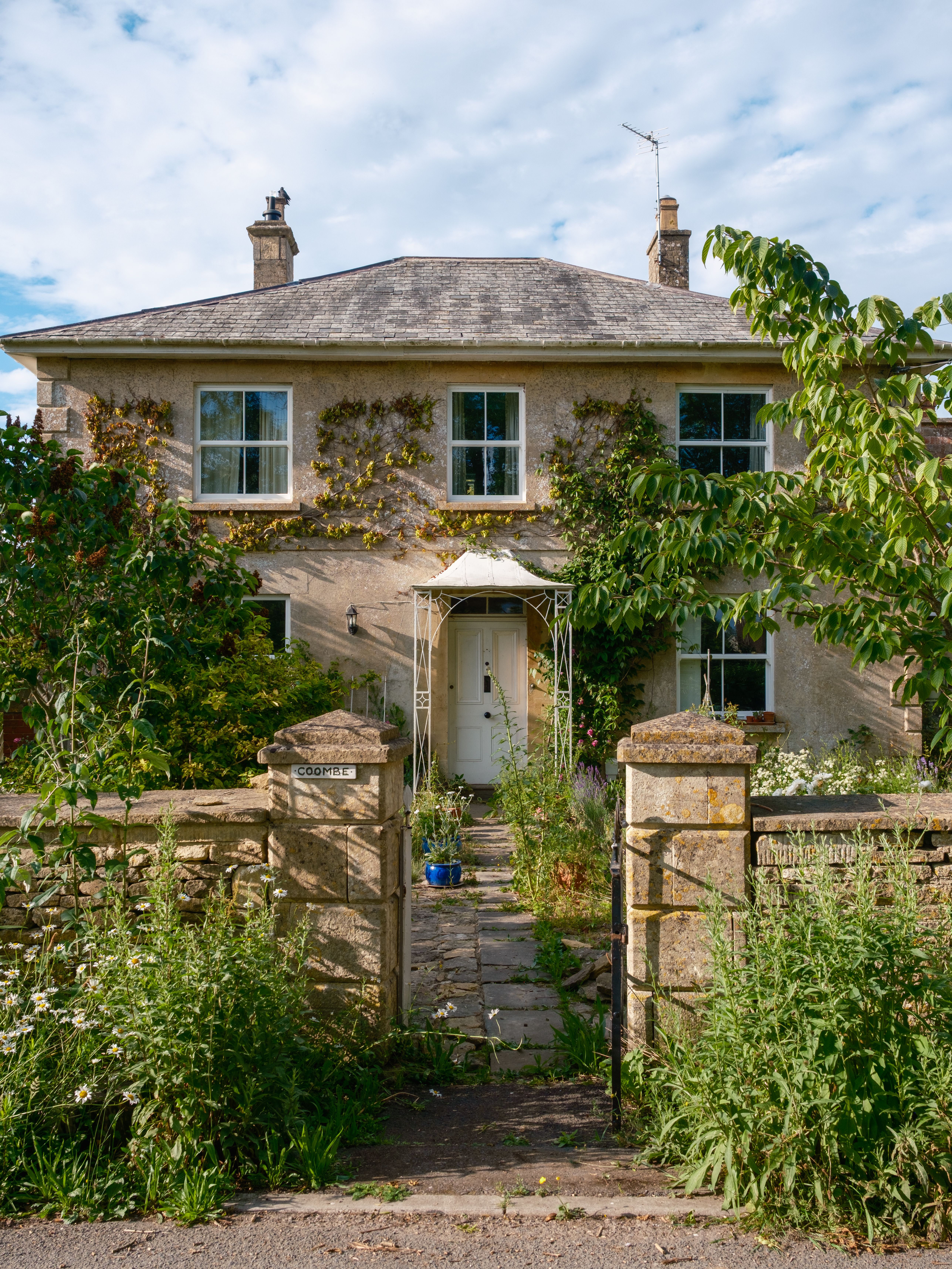 Picturesque cottage with a verdant garden pathway, invoking a serene and inviting ambiance.