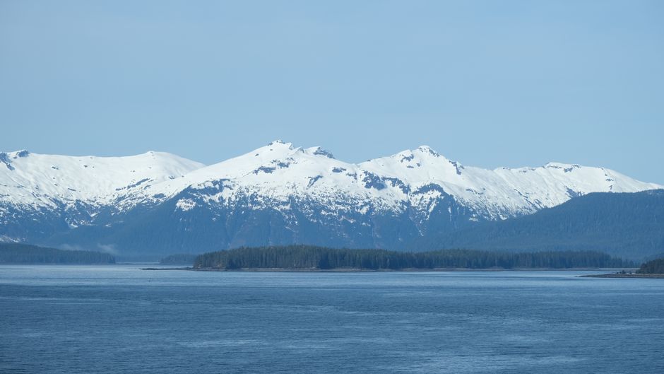 Unbeatable South Side Explorer with Glacier Landing Review: The Ultimate Denali Flightseeing Adventure Review 2026 - Spectacular view of snow-capped mountains in Alaska with a serene water foreground under clear blue skies.