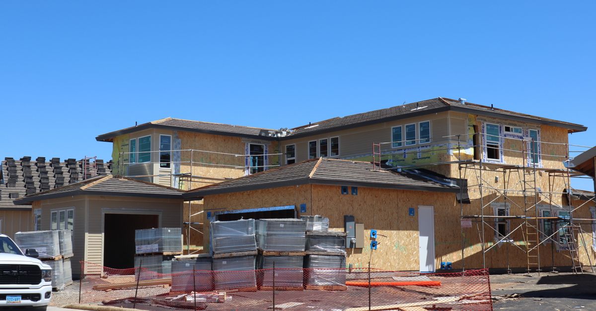 New modern house under construction in Elk Grove, CA, with scaffolding and materials visible.