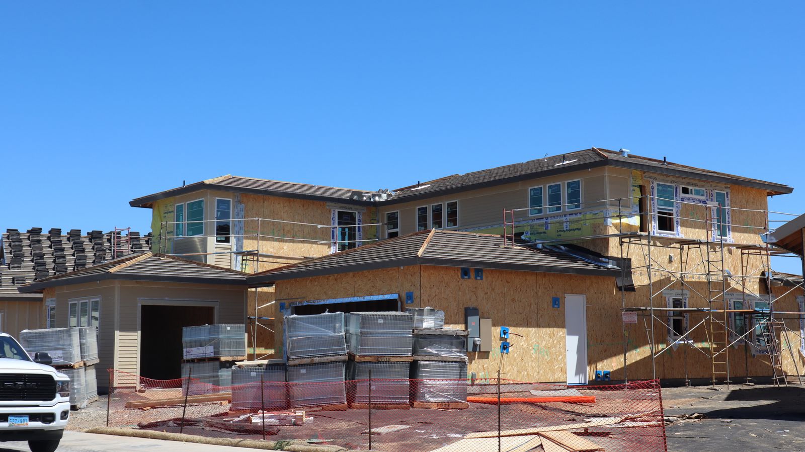 Résidence en construction avec échafaudage et matériaux sur un chantier résidentiel
