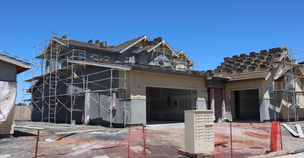 A modern residential house under construction with scaffolding, in Elk Grove, California.