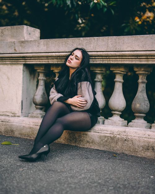 Stone Railing Sitting Contemplative Woman Sitting on Urban Stone Railing · Free Stock Photo