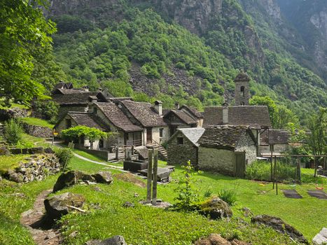 Picturesque Ticino village nestled in lush mountains, showcasing traditional stone houses and natural beauty.
