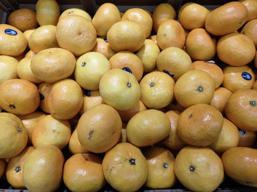 Free A pile of fresh oranges with vibrant colors in a market bin display. Stock Photo