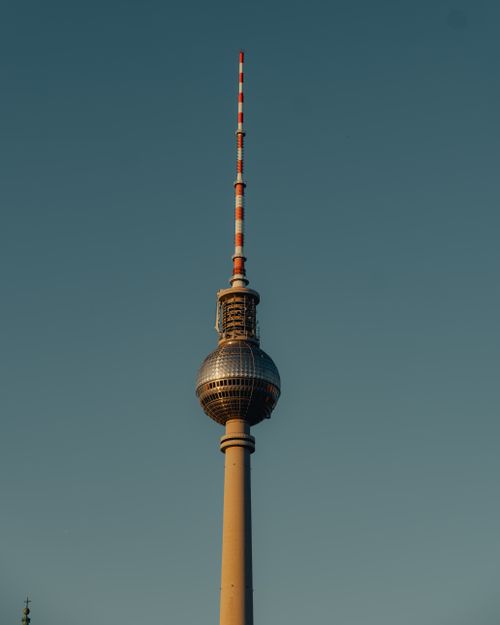 Free The iconic Berlin TV Tower rises against a clear sky at sunset, showcasing its unique architecture. Stock Photo