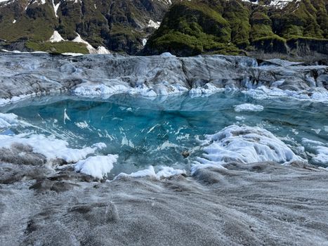 Beautiful glacial lagoon in Alaska with vibrant blue water and dramatic mountains.