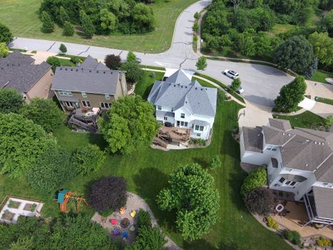 Bird's-eye view of residential area with green lawns and houses.