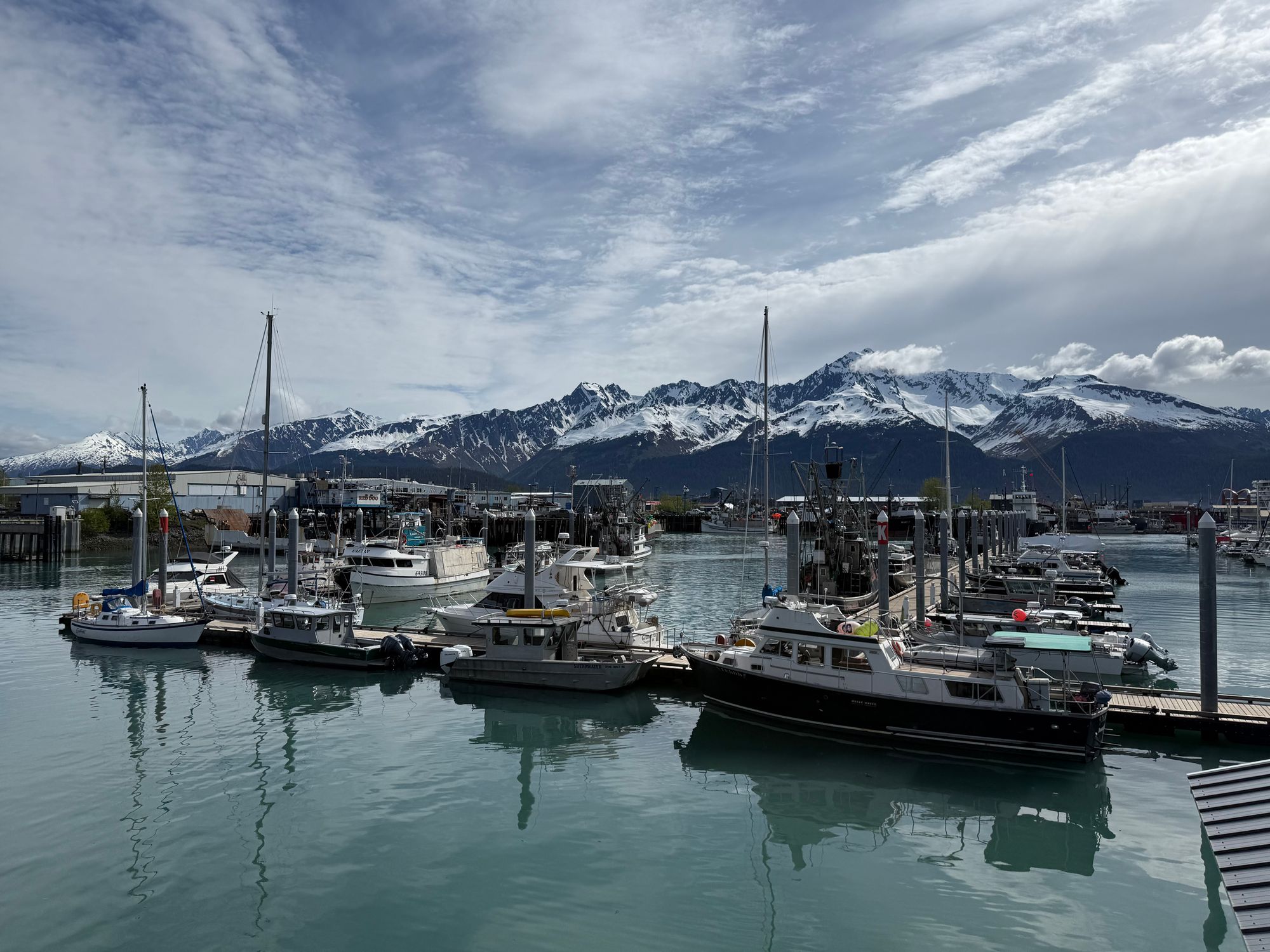 Boats docked at Seward Harbor with stunning snow-capped mountains in the background.