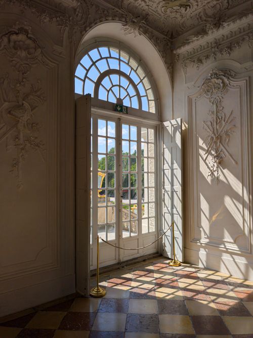 Free A sunlit ornate doorway with intricate details leading outdoors, casting beautiful shadows. Stock Photo