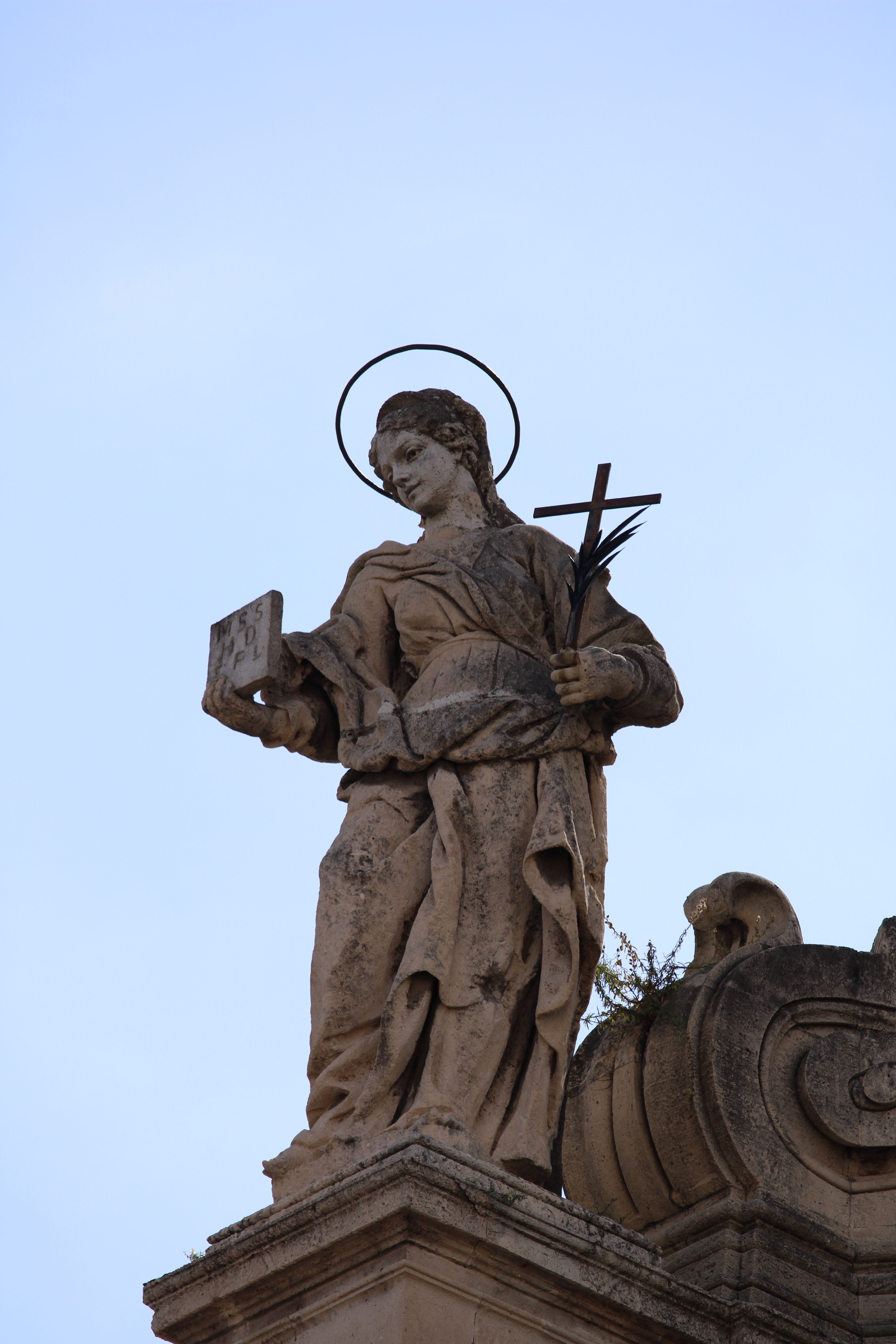 Intricately carved stone statue on a historic Italian building, capturing classic architectural elegance.