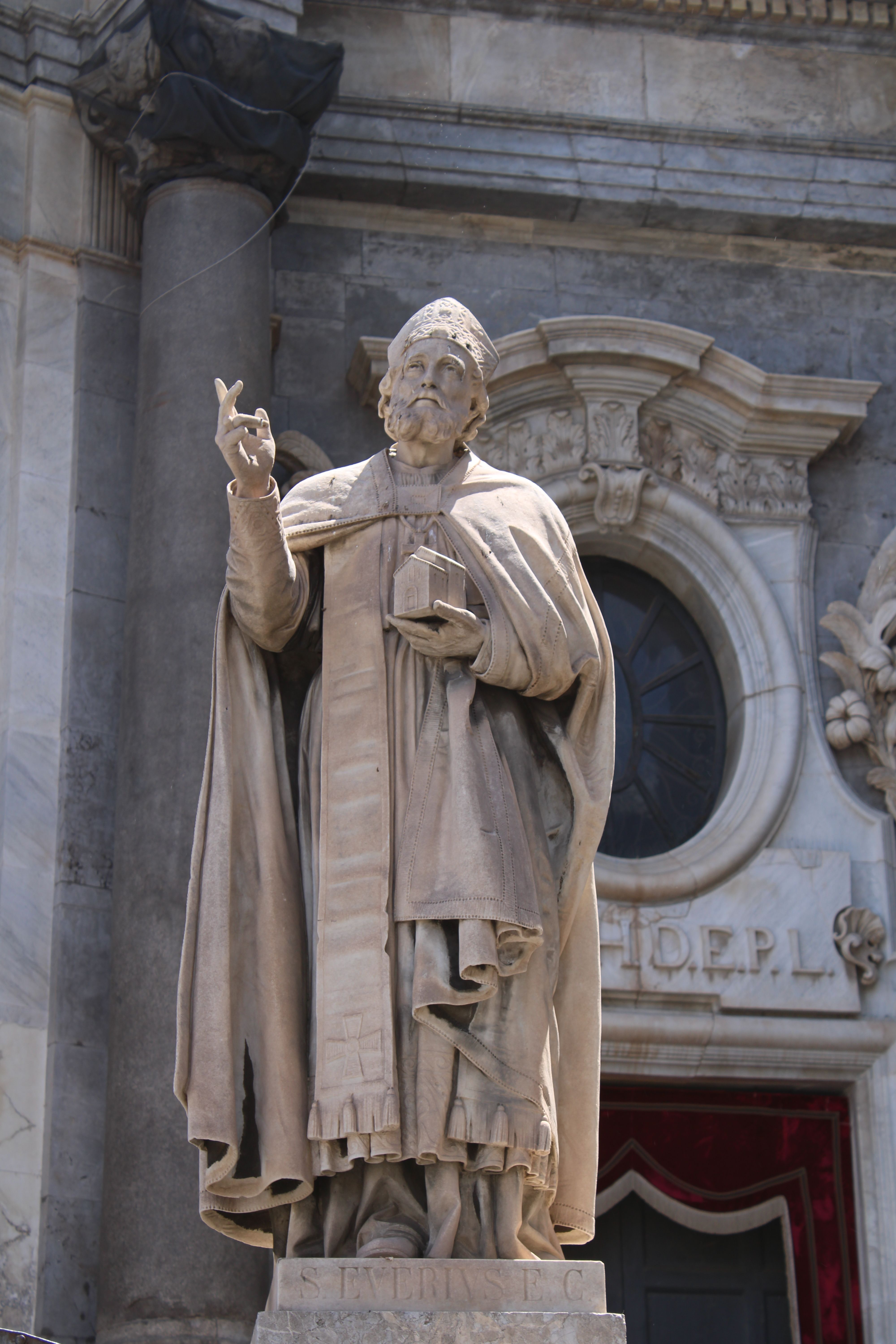 A detailed limestone statue against classic European architectural backdrop, showcasing baroque style.