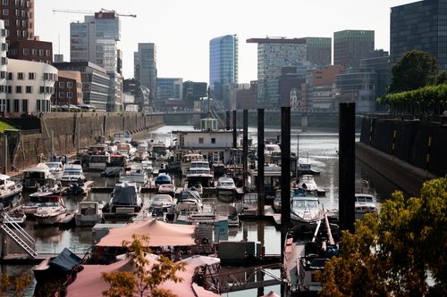 Free Vibrant view of boats docked in Düsseldorf's MedienHafen against a backdrop of modern architecture. Stock Photo