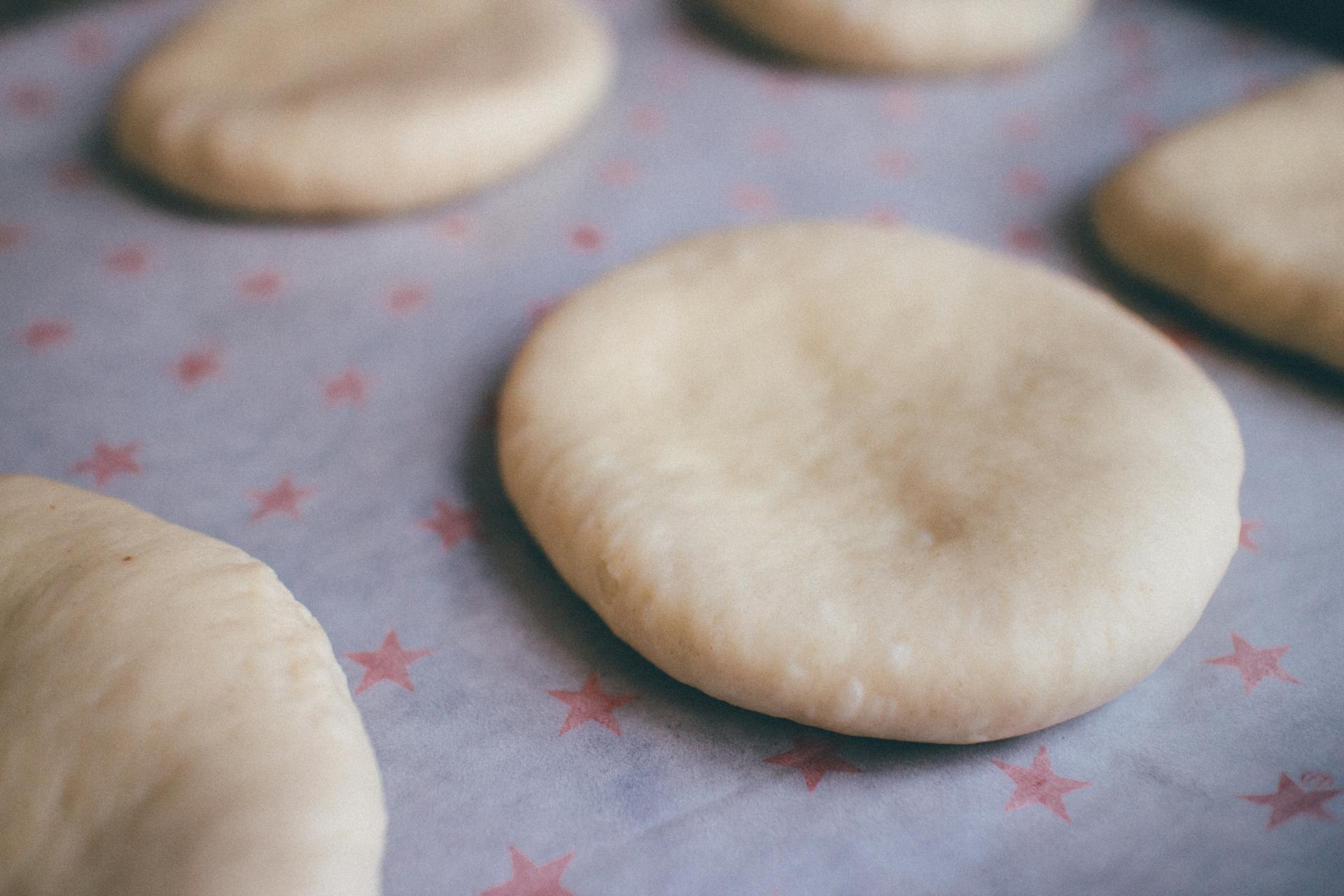 Close-up view of unbaked dough discs on star-patterned parchment paper, ready for baking.