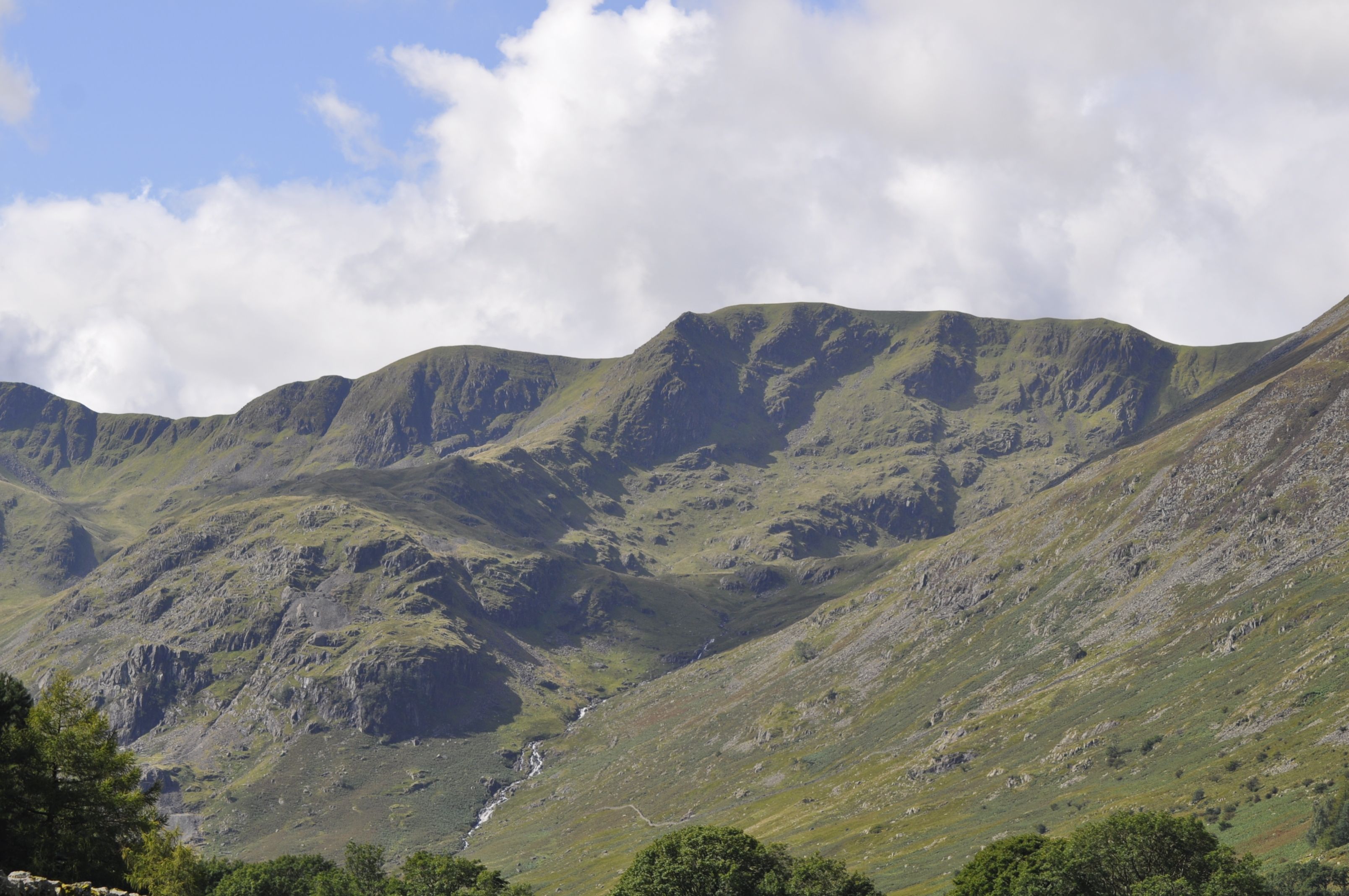 Scenic mountain view with lush greenery and dramatic skies in England.