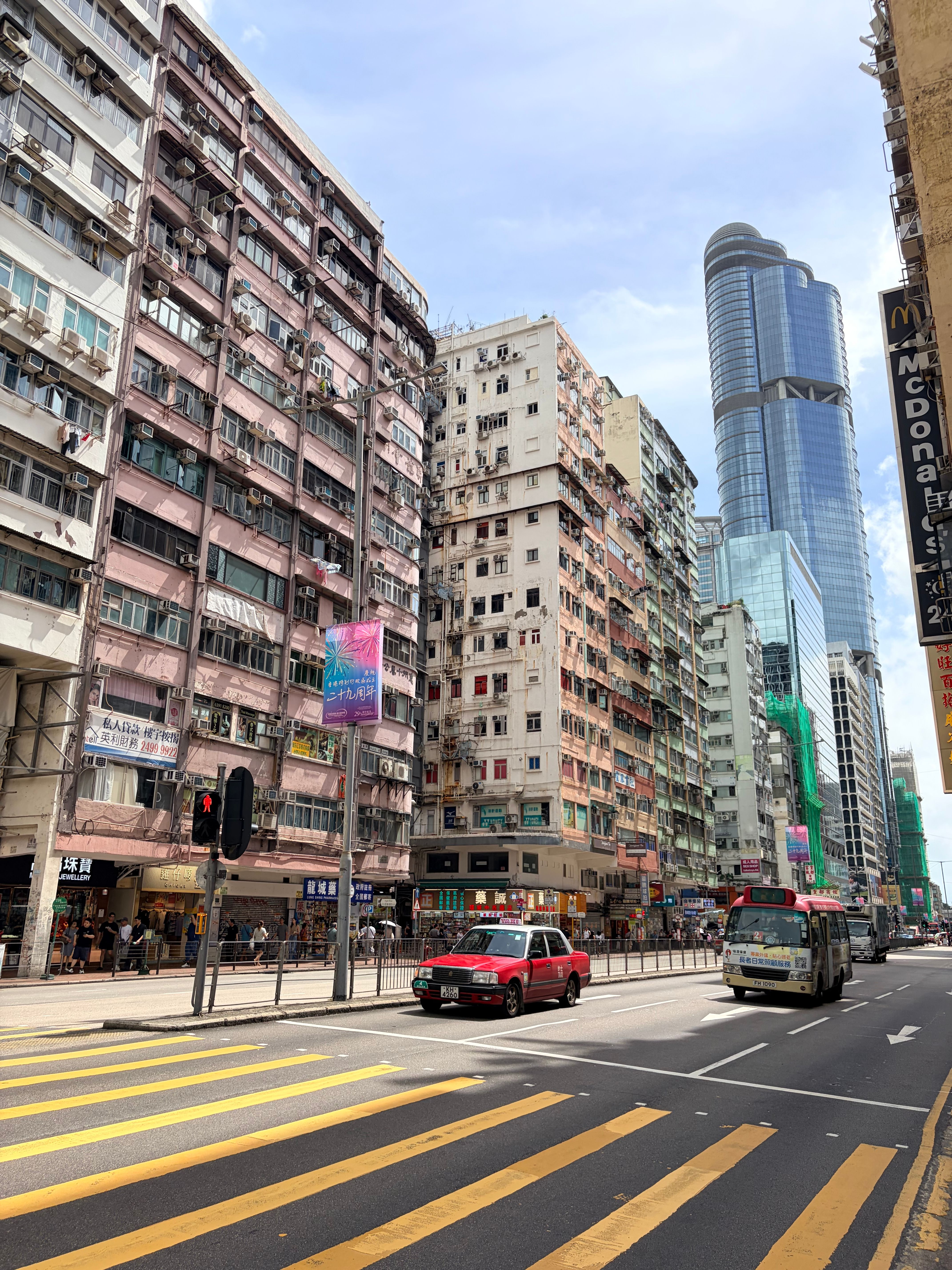 Vibrant scene of a busy street in Hong Kong, featuring historic buildings and modern skyscrapers.