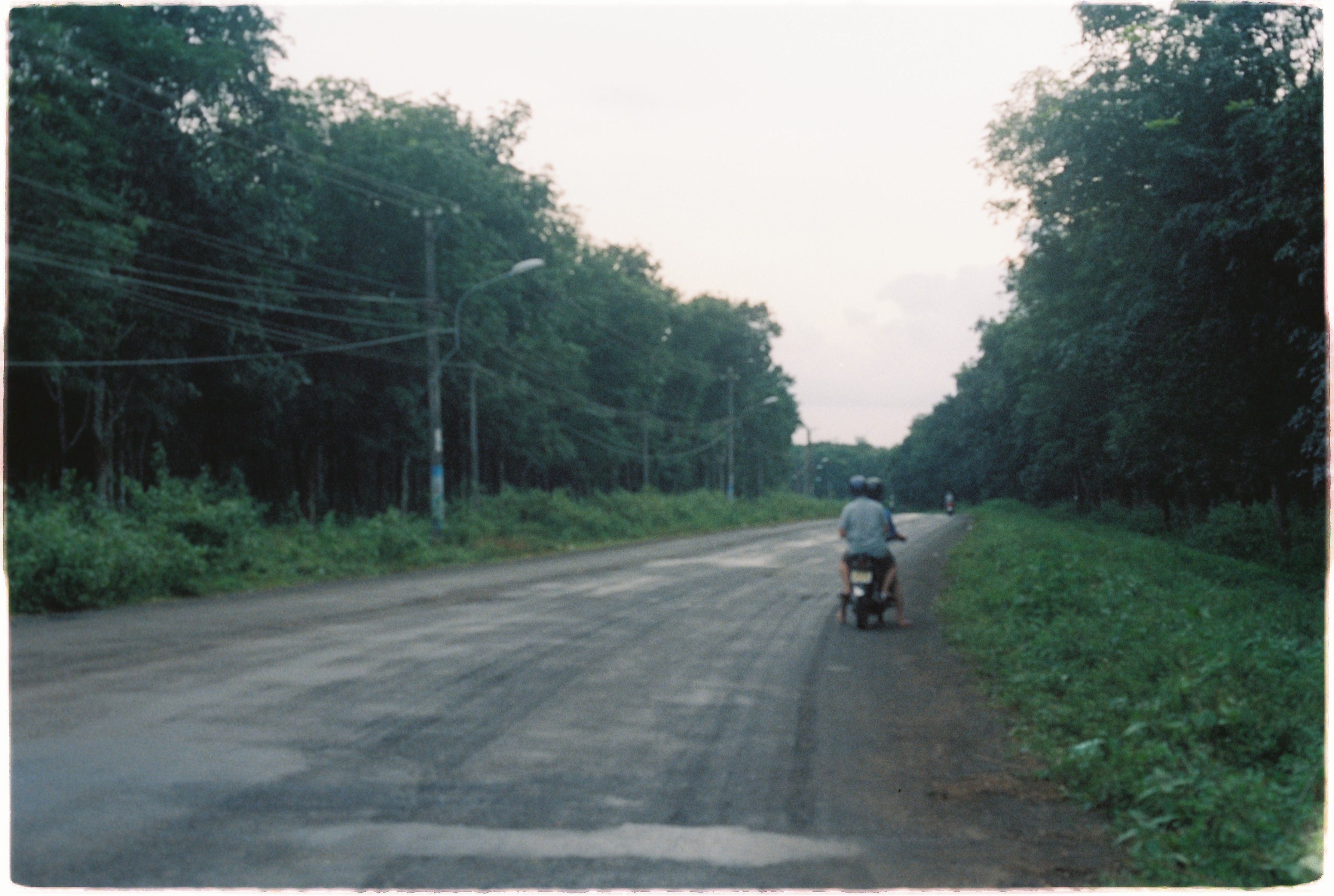 Digital nomad riding a scooter on a residential lane in Canggu, Bali, during their first month