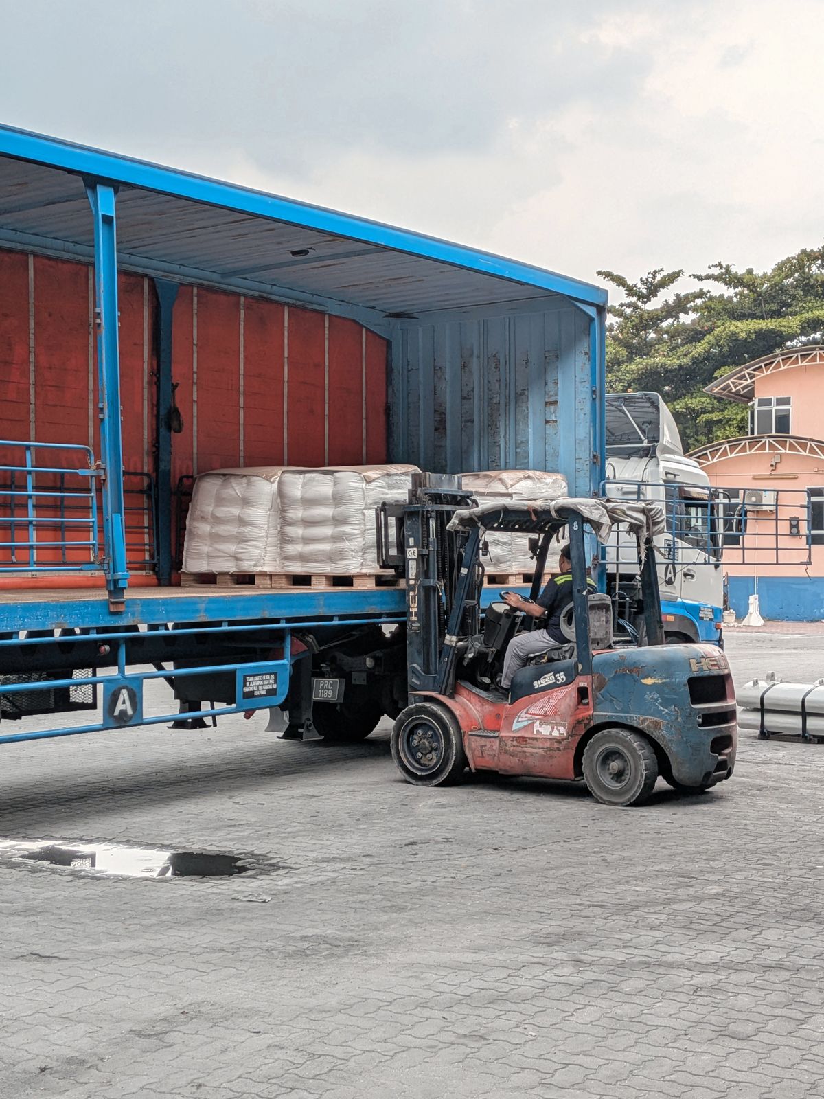 Forklift loading pallets into a lorry at an Ipoh depot, Malaysia — downtime is the real cost for a working lorry owner