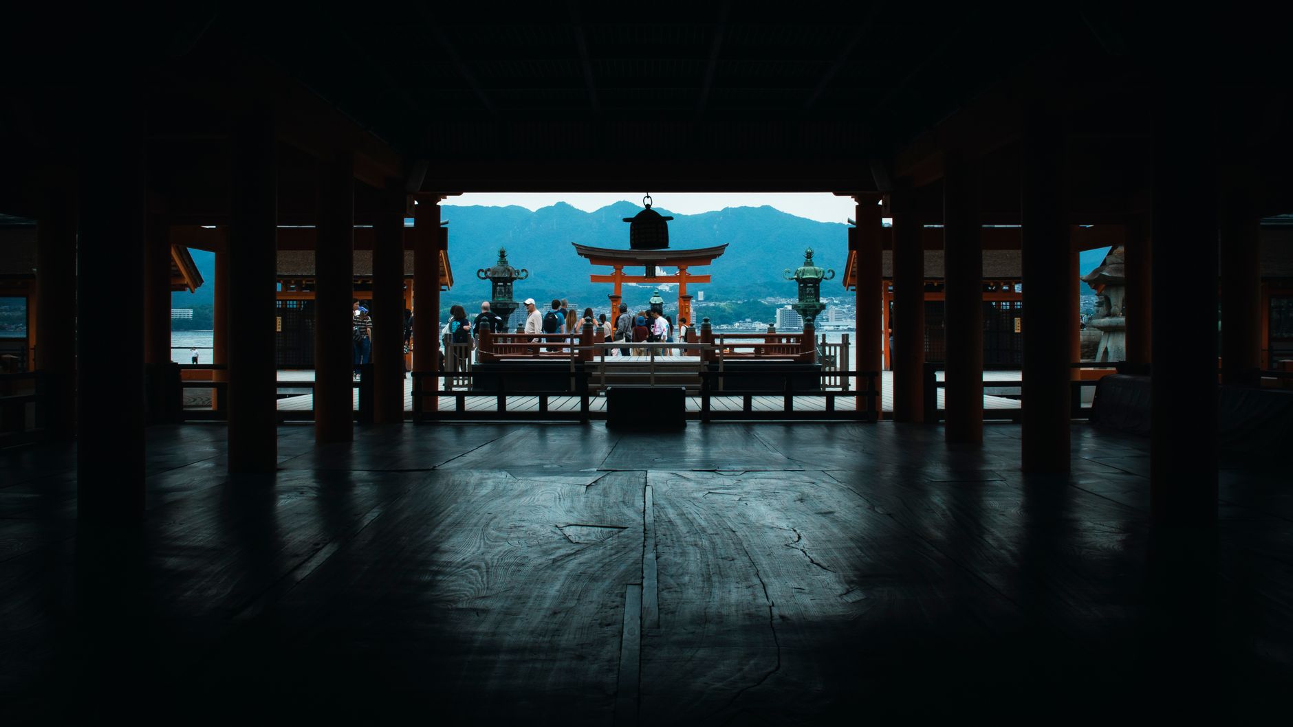 Silhouette view of Itsukushima Shrine with Torii gate and background mountains, Japan.