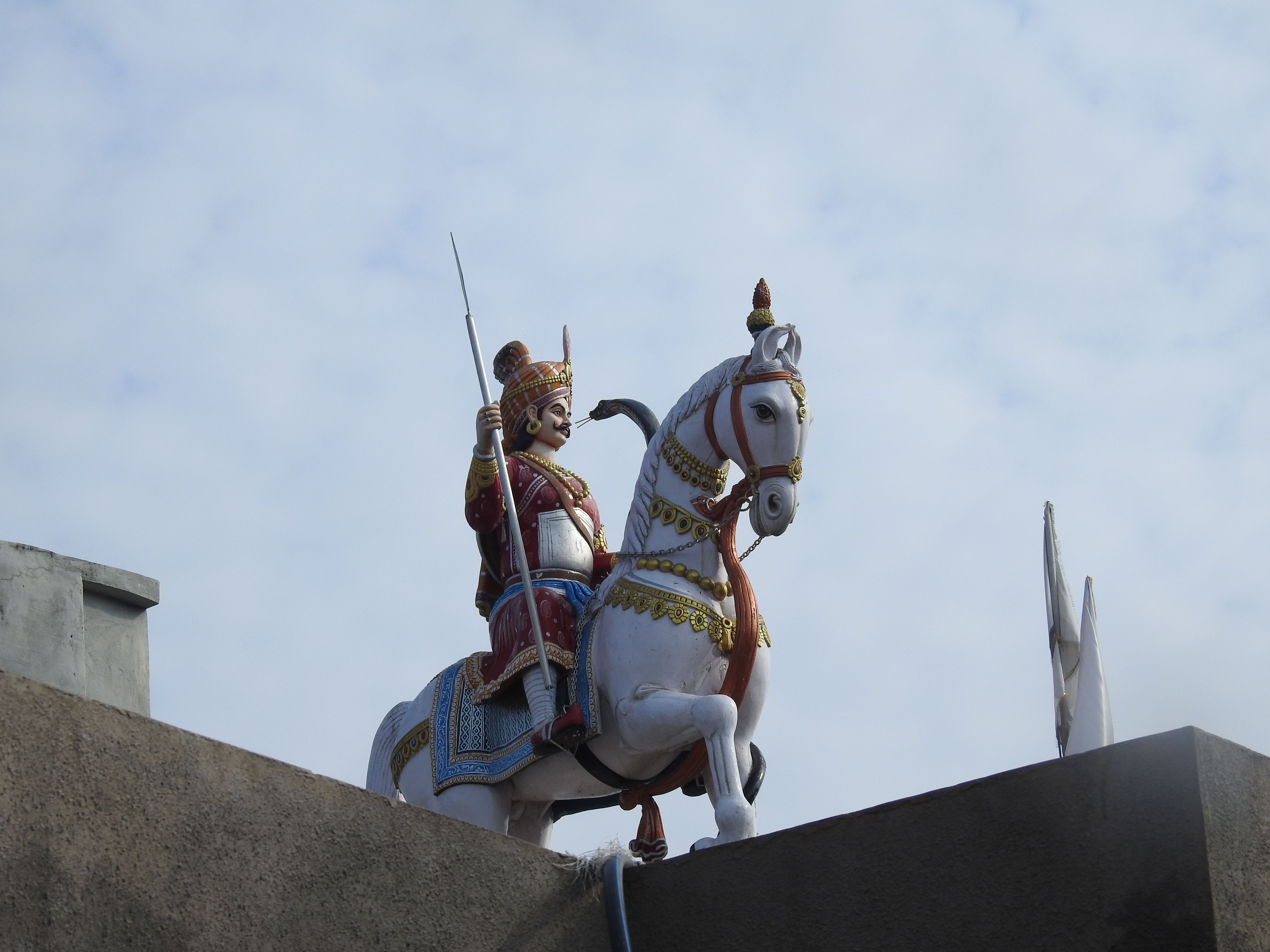 Colorful statue of a warrior on horseback, vividly capturing historical or mythical themes, set against a blue sky.
