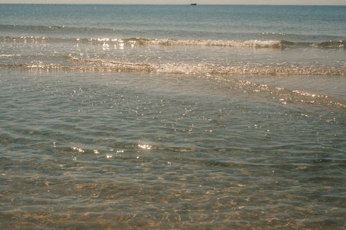 Free Gentle waves at sunrise on Phan Thiet beach, capturing peaceful ocean beauty. Stock Photo