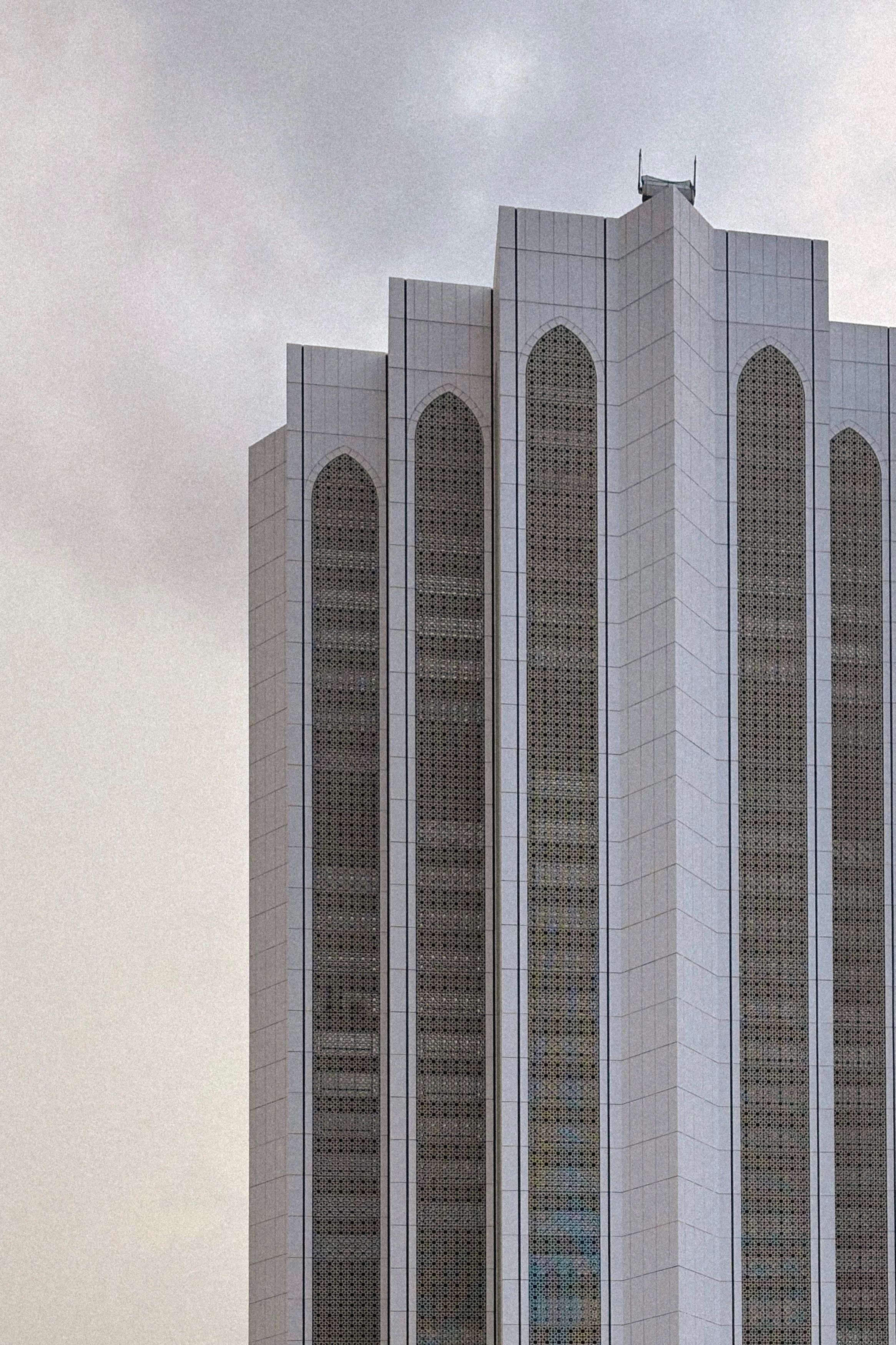 Towering modern skyscraper against a cloudy sky, showcasing urban architecture in Malaysia.