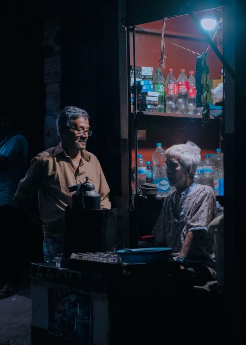 Free Local vendors operate a small shop in Dhaka at night, showcasing community life. Stock Photo
