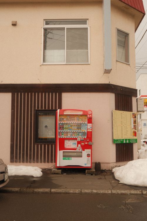 Free Vending machine outside a building on a snow-covered street in Japan. Stock Photo