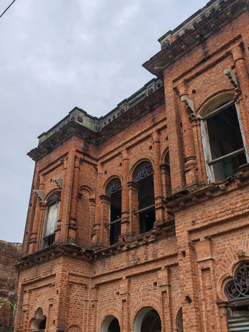 Free Old brick building with intricate arches and windows, showcasing historic architecture. Stock Photo