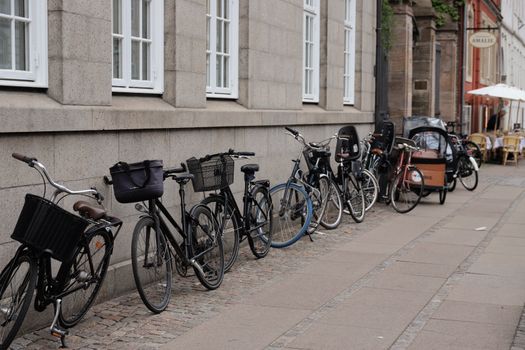 Row of parked bicycles along a street in Copenhagen, Denmark, showcasing urban cycling culture.